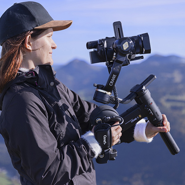 Woman filming with a Zhiyun Crane 3S stabilizer, a Sony Z90 / AX700 camcorder controlled by the Caman S GRIP PRO